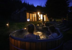 Two people enjoying an evening hot tub session at Forest Retreats